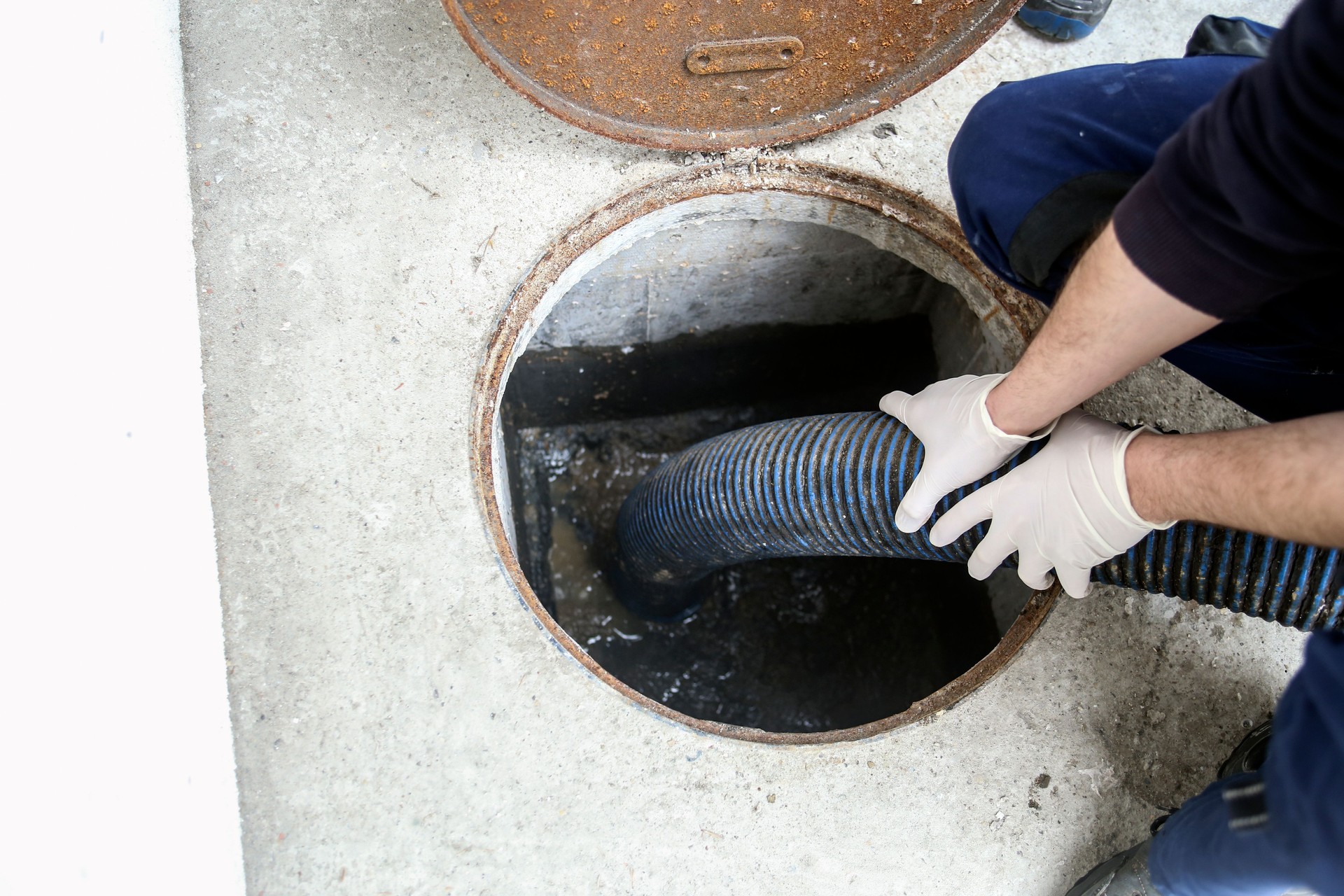 Worker cleaning sludge from a septic tank